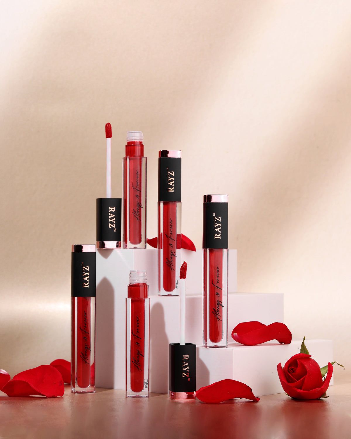 Lipsticks on white plinths with rose petals